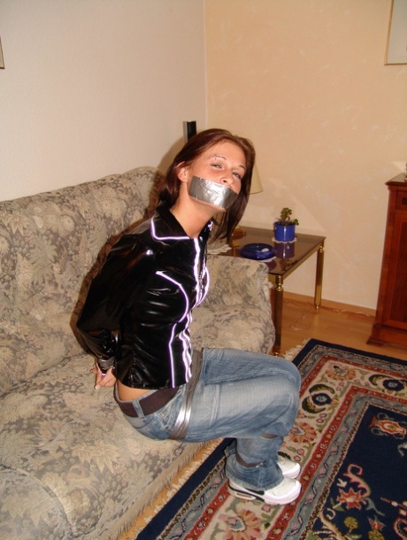 Caucasian girl is silenced and bound with duct tape on a couch in her clothing 32475626