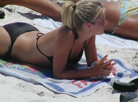 Candid action of amateur girls soaking up the rays on a beach in bikinis 97516081