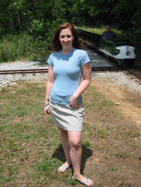 Pale redhead uncovers her small boobs near model railroad tracks 71117932