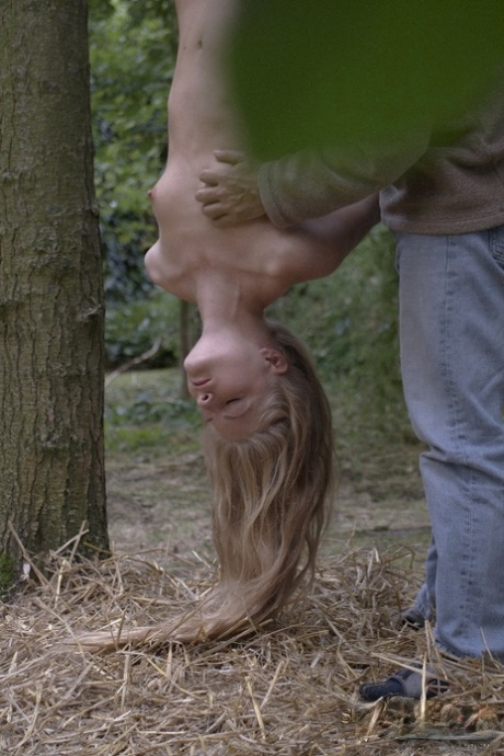 Young blonde girl has her hair pull after being suspended upside down in woods 22839312