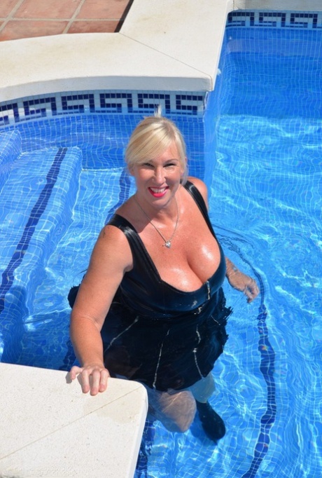 Thick blonde woman Melody goes for a swim in a black latex dress 53410129