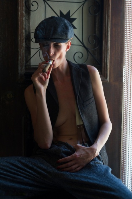 British chick Rebecca Leah smokes a cigar while exposing her boobs in a vest 82185045