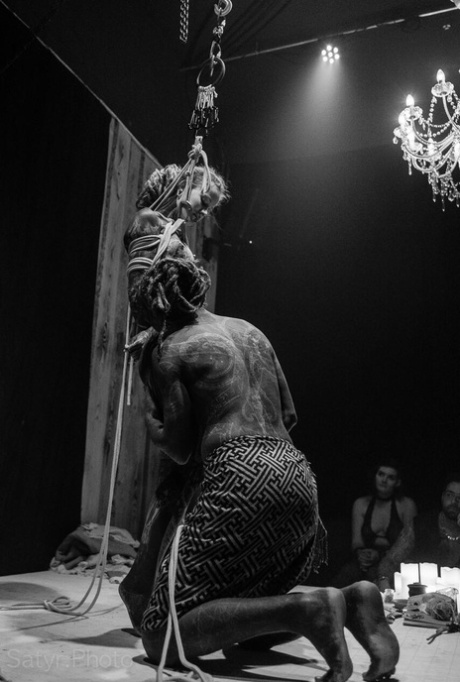 Heavily tattooed female is tied up with rope and suspended from a ceiling 22755282
