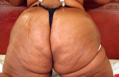 Ebony fatty Brenda Brickhouse puts a shine on her huge ass atop a bed 18663931