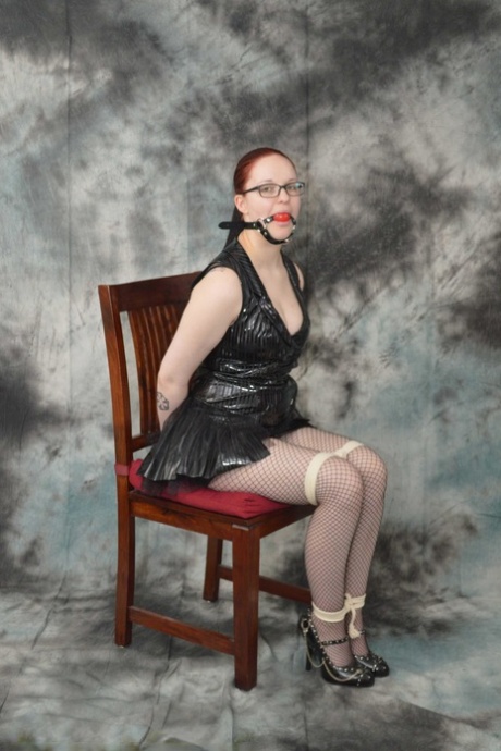 Redhead Lady Nadja is gagged & restrained before being covered with a raincoat 56243899