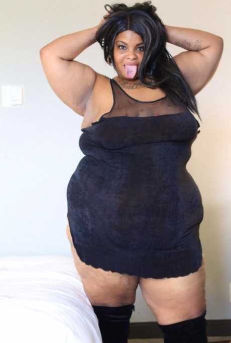 Ebony SSBBW Carmel Squirtz releases her massive ass from a black dress 77704239