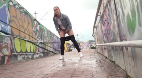 Solo girl Naomi Bennet pulls down black leggings to pee while on a footbridge