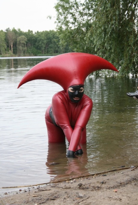 Fetish model Avengelique wades into a body of water in a rubber costume 32835388