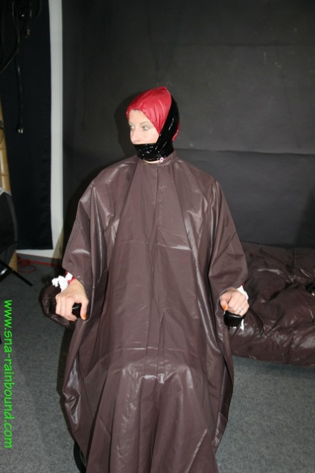 Amateur model Pia is tied to a hairdresser chair in a raincoat while gagged