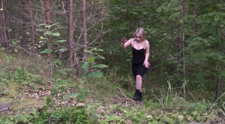 Blonde girl hikes up a black dress to piss in the woods while wearing Docs 23455136
