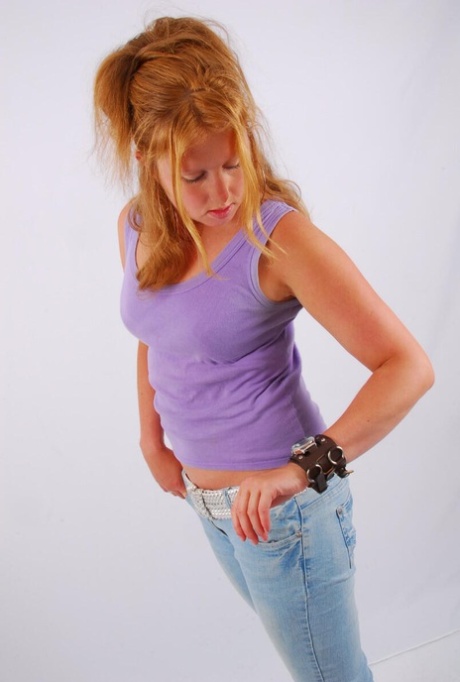 Natural redhead models a large cuff watch in a tank top and faded jeans 61061849