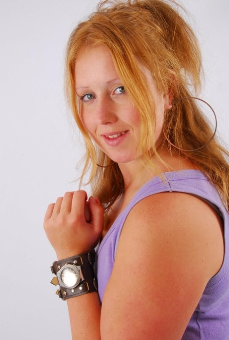 Natural redhead models a large cuff watch in a tank top and faded jeans 61061849
