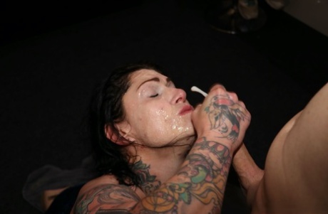 Tattooed brunette receives facial cumshot during a bukkake gig 88681800