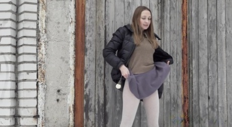 Caucasian girl Valya takes a piss in the snow after ducking behind a building