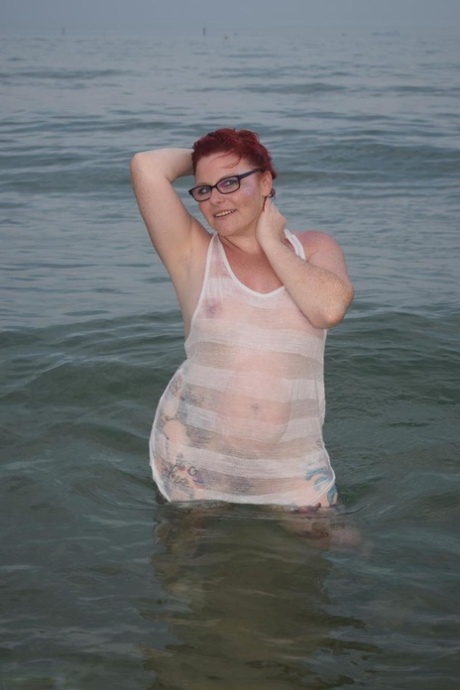 Mature redhead Mollie Foxxx wets her tattooed body in the ocean 84750104