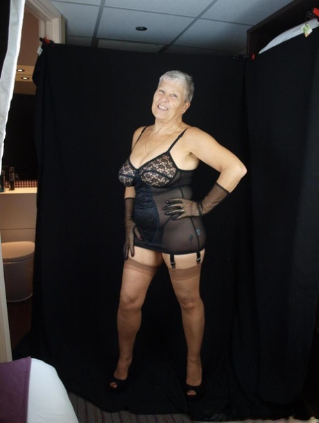 Silver haired woman Savana models lingerie and tan nylons while wearing gloves 93772682