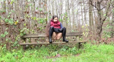 Lara Fox pulls down her pants to pee on a bench beside a path in the woods 62659205
