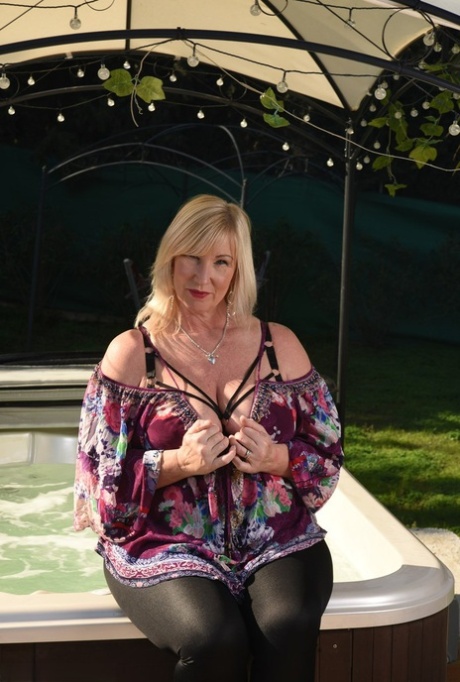 Fat older blonde Melody peels off black leggings afore an outdoor hot tub 73060153