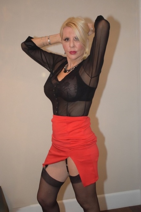 Older blonde Emerald lifts up her skirt while wearing a garter belt and nylons 46803550