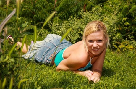 Barely legal blonde masturbates with a vibrator on a lawn near some bushes 60596294