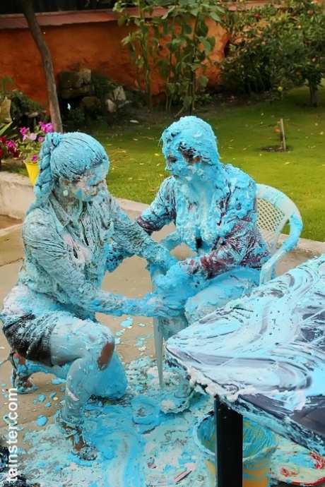 Lesbian women turn each other blue during messy food play on a patio 22504161