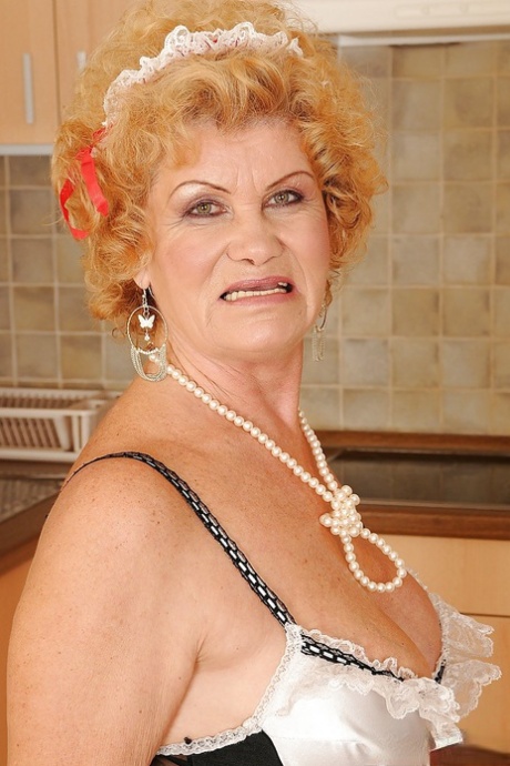 Lusty granny in maid uniform and stockings stripping in the kitchen 51298508